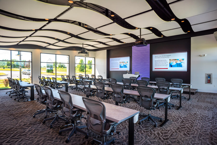 Conference hall with tables and chairs facing projector screens