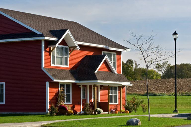 Red house with sunlight illuminating the front of the house