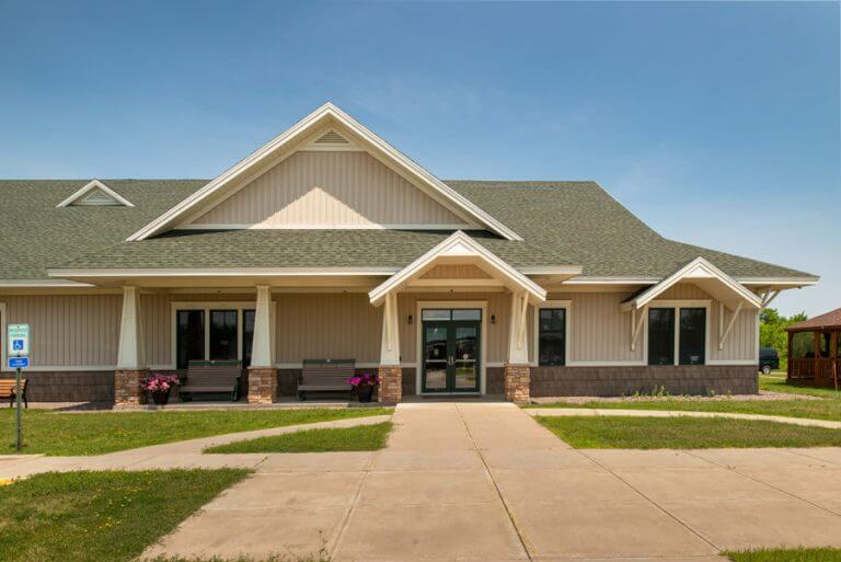 exterior of municipal building with gabled roof and covered entrance