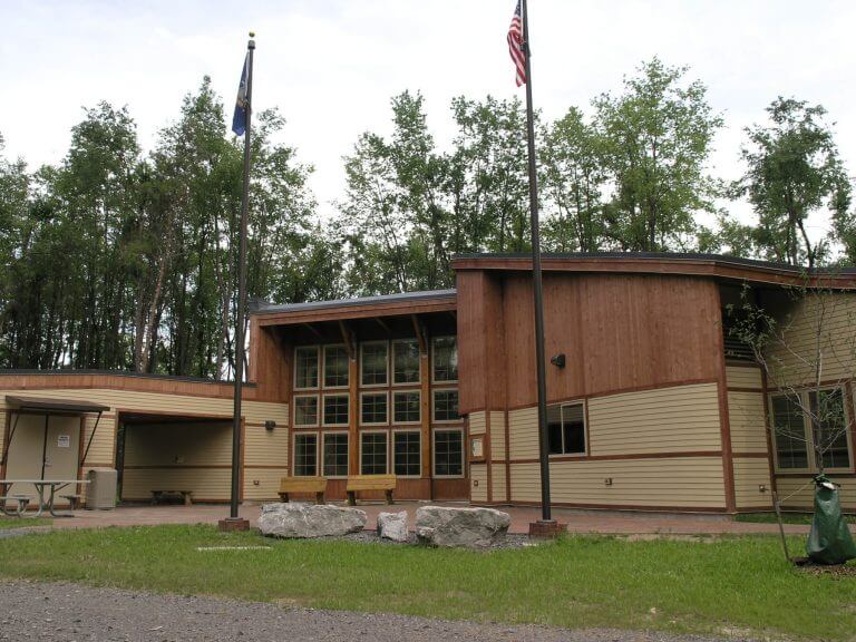 science center with large windows and flag poles in front