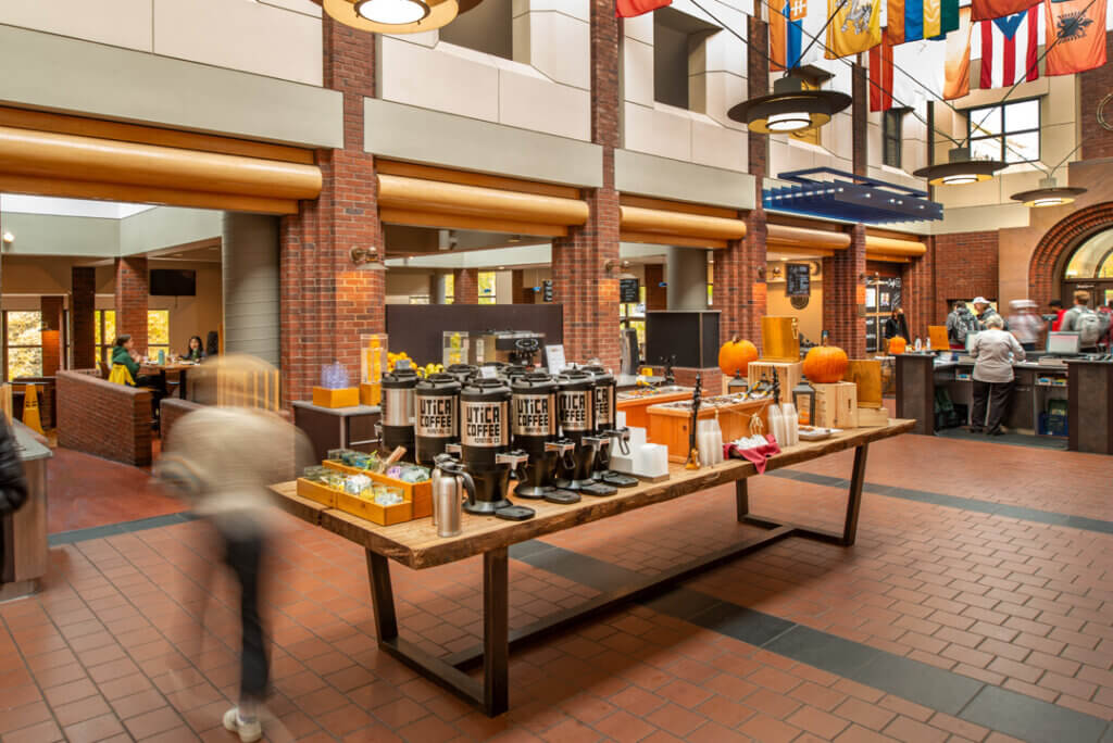 Large timber table with coffee carafes located in the center of the dining hall