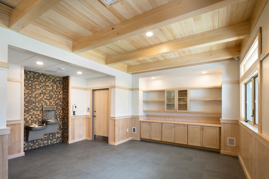 Entry vestibule featuring durable flooring, wood accents, and energy-efficient design elements
